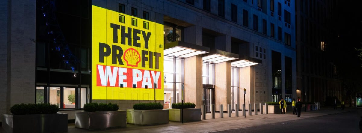 Greenpeace projection exposes source of Shell’s Profits Greenpeace activists project the truth about the source of Shell’s huge profits onto their global headquarters by the Thames in London as well as next to a Shell petrol station. The projections include the messages “They Profit We Pay”, “War Profiteers”, “At Least We are Making Billions”, “War Profits HQ” and “Making a killing”.