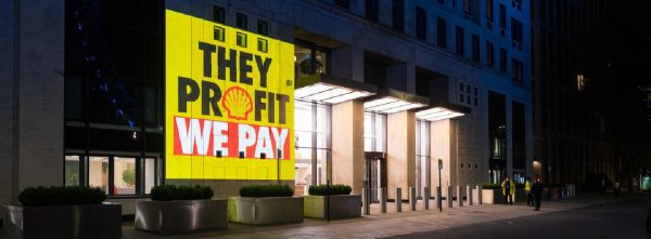 Greenpeace projection exposes source of Shell’s Profits Greenpeace activists project the truth about the source of Shell’s huge profits onto their global headquarters by the Thames in London as well as next to a Shell petrol station. The projections include the messages “They Profit We Pay”, “War Profiteers”, “At Least We are Making Billions”, “War Profits HQ” and “Making a killing”.